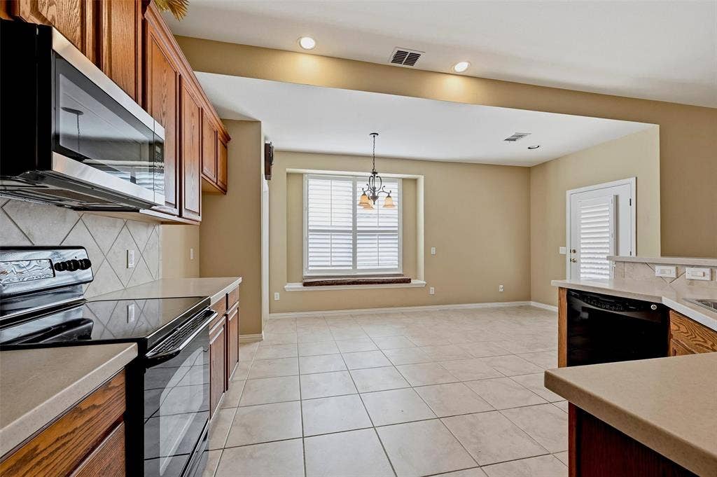 819 Mustang Drive, Fairview, TX 75069 Kitchen featuring wood cabinetry, solid surface countertops, tile flooring, built-in window seat, and diamond-pattern tile backsplash