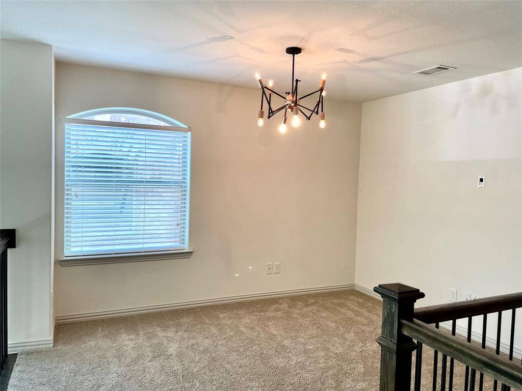4213 Arbrook Way, Plano, TX 75074 Multi-arm sputnik-style chandelier, arched-top window with horizontal blinds, neutral wall-to-wall carpeting, and wood-finish banister with metal spindles