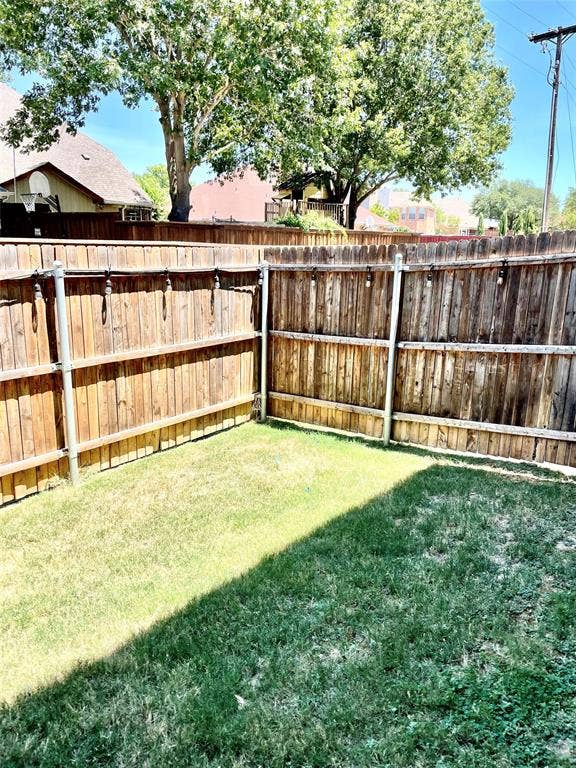 4213 Arbrook Way, Plano, TX 75074 Fenced backyard featuring wood-plank perimeter fencing with metal posts and attached string lighting