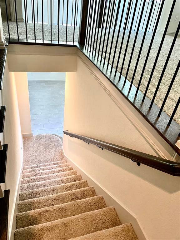 4213 Arbrook Way, Plano, TX 75074 Staircase featuring wall-to-wall carpeting, wood-finish handrail, and a black metal balustrade
