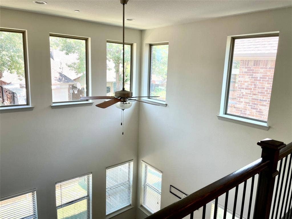 4213 Arbrook Way, Plano, TX 75074 Double-height ceiling featuring large windows, recessed lighting, a central ceiling fan with integrated light fixture, and a wooden handrail