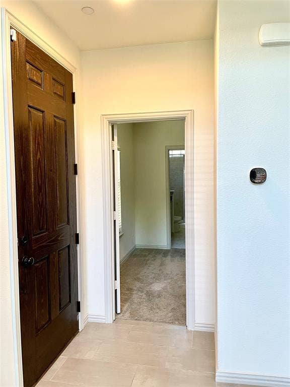 4213 Arbrook Way, Plano, TX 75074 Stained wood six-panel door with matte black hardware, neutral tile flooring, and integrated wall-mounted thermostat