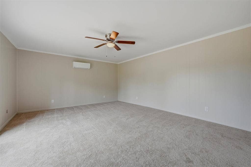 607 N Louisiana Drive, Celina, TX 75009 Neutral wall paneling, wall-mounted ductless heating and cooling unit, ceiling fan with light kit, and neutral carpeting