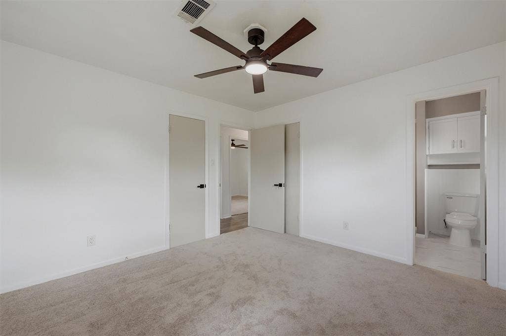 607 N Louisiana Drive, Celina, TX 75009 Neutral-toned carpeting, ceiling fan with integrated lighting, and multiple interior doors with matte black hardware