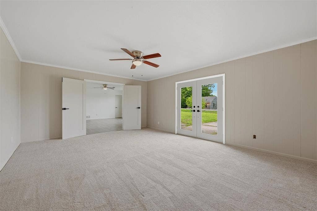 607 N Louisiana Drive, Celina, TX 75009 Neutral-toned interior space featuring wall-to-wall carpeting, a ceiling fan with integrated lighting, dual-panel interior doors, and a double glass door exterior entrance