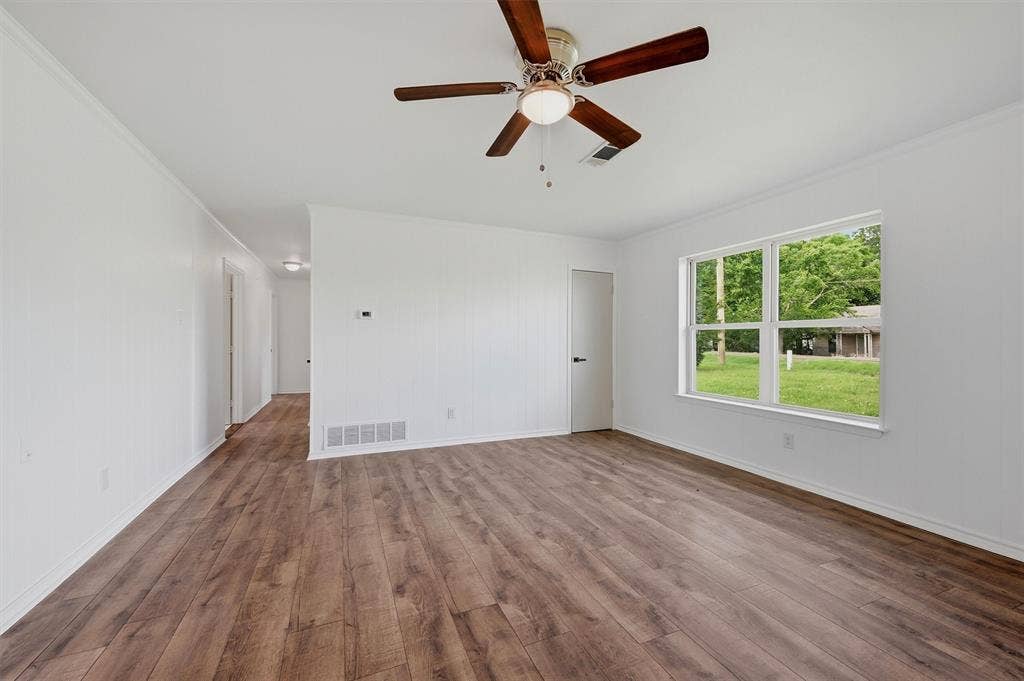 607 N Louisiana Drive, Celina, TX 75009 Interior space featuring wood-finish flooring, a ceiling fan with integrated lighting, neutral wall finishes, and a window with white trim