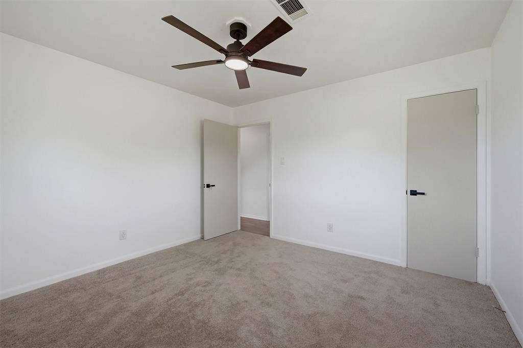 607 N Louisiana Drive, Celina, TX 75009 Neutral-toned carpeted flooring, multi-blade ceiling fan with integrated lighting, and doors featuring matte black hardware
