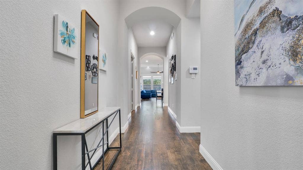 124 Village Creek Drive, McKinney, TX 75071 Hallway featuring arched architectural details, wood-finish flooring, and recessed lighting