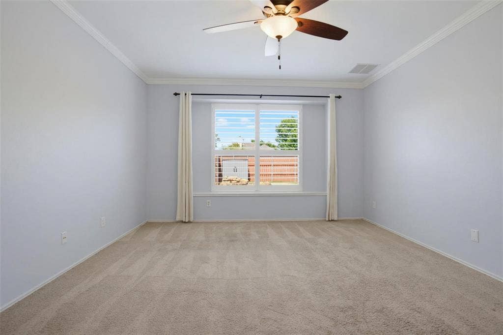 1402 Bradford Trace Drive, Allen, TX 75002 Spacious interior featuring neutral carpeting, crown molding, a ceiling fan with integrated lighting, and a window with plantation shutters