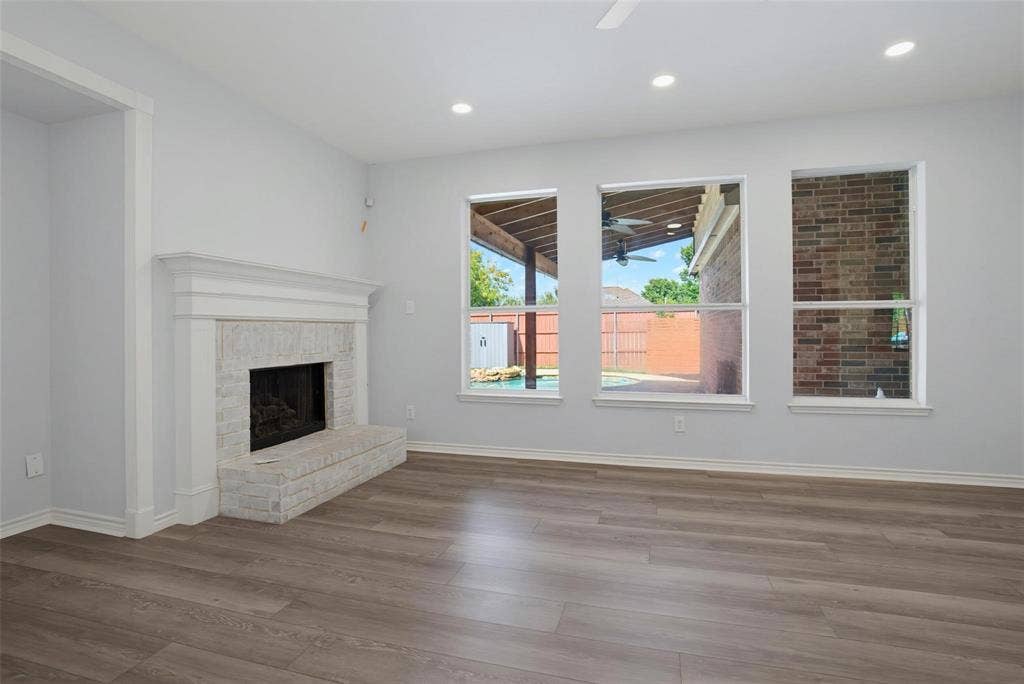 1402 Bradford Trace Drive, Allen, TX 75002 Interior featuring wood-finish flooring, recessed lighting, and a white brick fireplace with a custom mantle