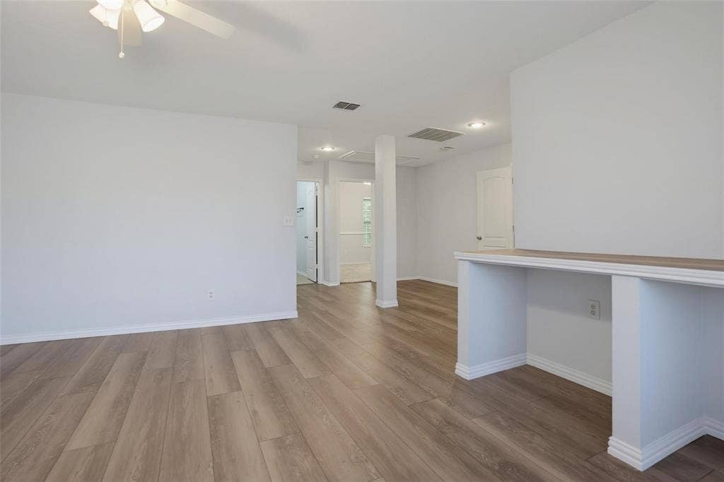 1402 Bradford Trace Drive, Allen, TX 75002 Open floor plan featuring wood-finish flooring, recessed lighting, a ceiling fan, and a built-in counter surface