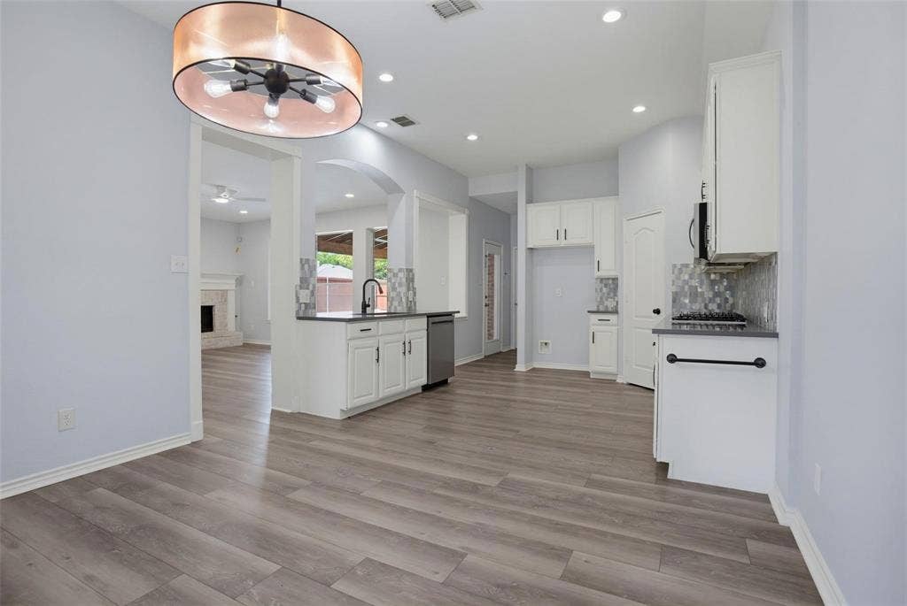 1402 Bradford Trace Drive, Allen, TX 75002 Kitchen featuring white shaker-style cabinetry, dark stone-finish countertops, mosaic tile backsplash, wood-finish flooring, and a drum-style pendant light fixture