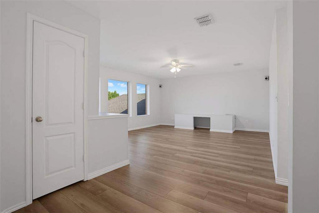 1402 Bradford Trace Drive, Allen, TX 75002 Interior space featuring wood-finish flooring, a neutral color palette, dual windows, a ceiling fan with integrated lighting, and built-in cabinetry