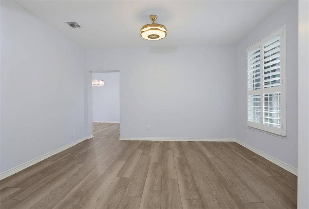 1402 Bradford Trace Drive, Allen, TX 75002 Interior space featuring wood-finish flooring, white plantation shutters, and a modern drum-style flush-mount light fixture