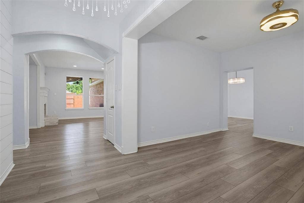 1402 Bradford Trace Drive, Allen, TX 75002 Architectural archways, wood-finish flooring, recessed lighting, and multi-tier pendant fixtures