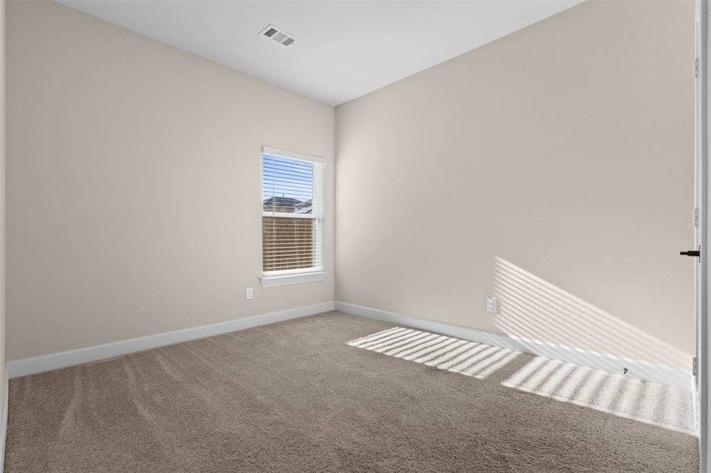 Neutral-toned interior space featuring neutral wall paint, carpeted flooring, and a single-pane window with installed blinds