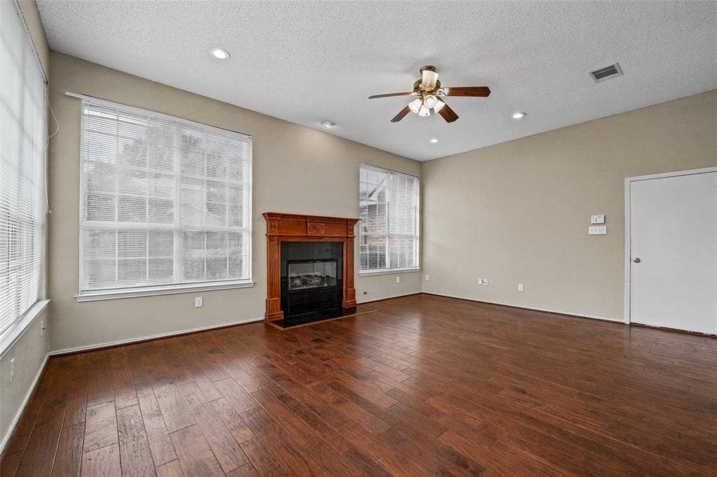 714 Cottonwood Bend Drive, Allen, TX 75002 Living space featuring wood-finish flooring, a fireplace with a decorative wood mantel, multiple large windows, and recessed lighting
