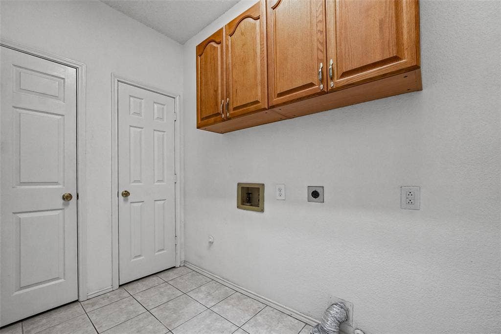 714 Cottonwood Bend Drive, Allen, TX 75002 Utility area featuring tile flooring, wood-finish wall-mounted cabinetry, and dedicated washer and dryer hookups