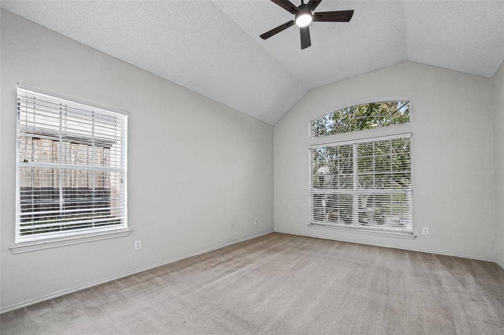 714 Cottonwood Bend Drive, Allen, TX 75002 Vaulted ceilings featuring a central ceiling fan, arched transom window, and neutral carpeting
