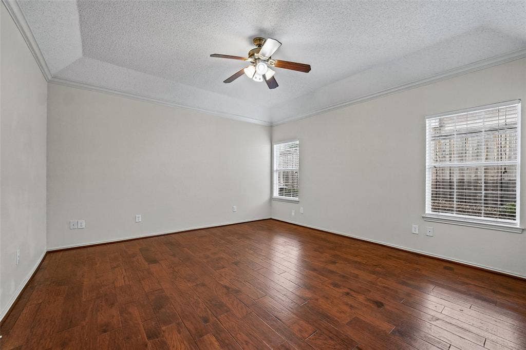 714 Cottonwood Bend Drive, Allen, TX 75002 Tray ceiling featuring crown molding, wood-finish flooring, and a multi-blade ceiling fan with integrated lighting