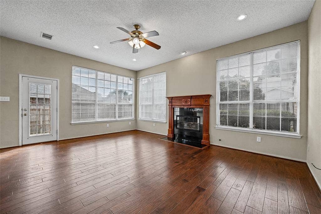 714 Cottonwood Bend Drive, Allen, TX 75002 Wood-finish flooring, fireplace with a decorative mantel, multiple large windows, recessed lighting, and a ceiling fan