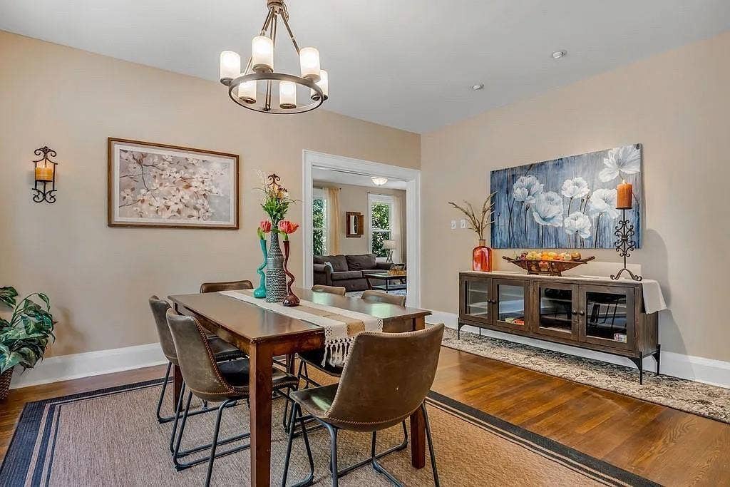 Dining area featuring wood-finish flooring, a multi-light chandelier, and decorative wall-mounted light fixtures
