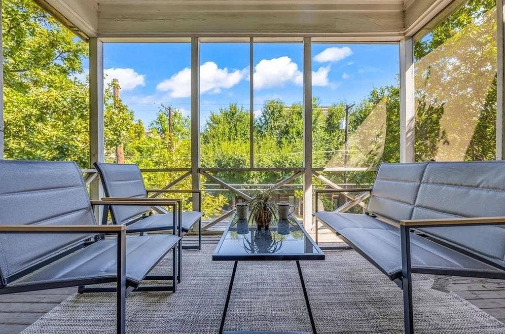 Screened porch featuring wood-plank flooring, structural timber framing, cross-brace decorative detailing, and full-height mesh screening
