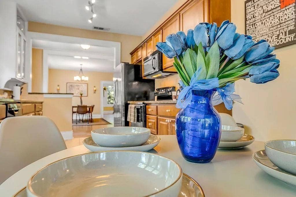 Kitchen featuring wood cabinetry, stone countertops, stainless steel appliances, and built-in track lighting