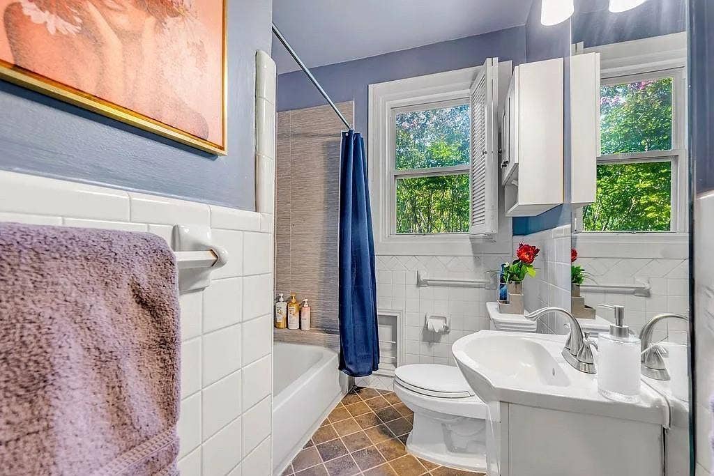 Bathroom featuring white subway tile wall surrounds, a pedestal sink with a dual-handle faucet, a built-in medicine cabinet, and a bathtub with a tiled enclosure