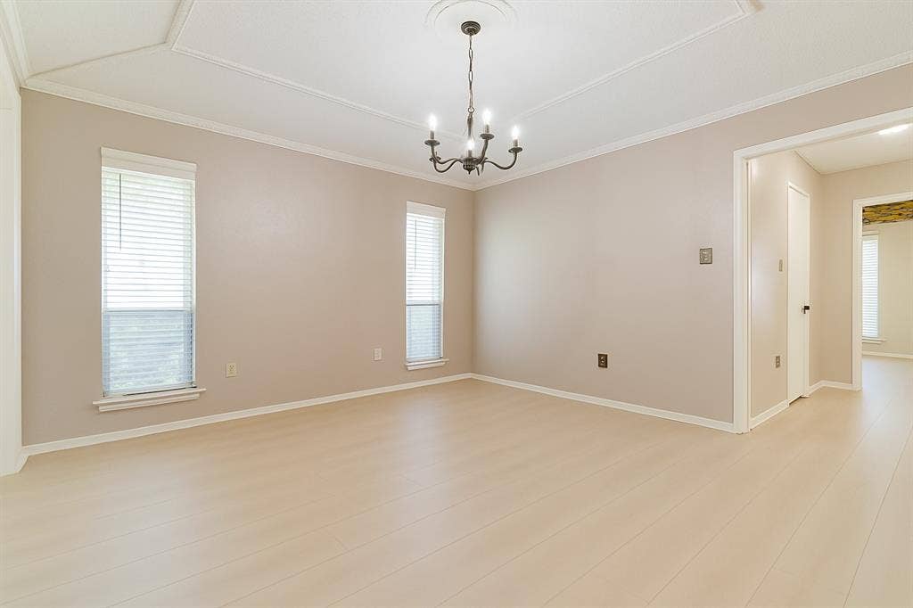 2007 Mistletoe Drive, Richardson, TX 75081 Primary bedroom with light wood-type flooring, a chandelier, crown molding, and baseboards