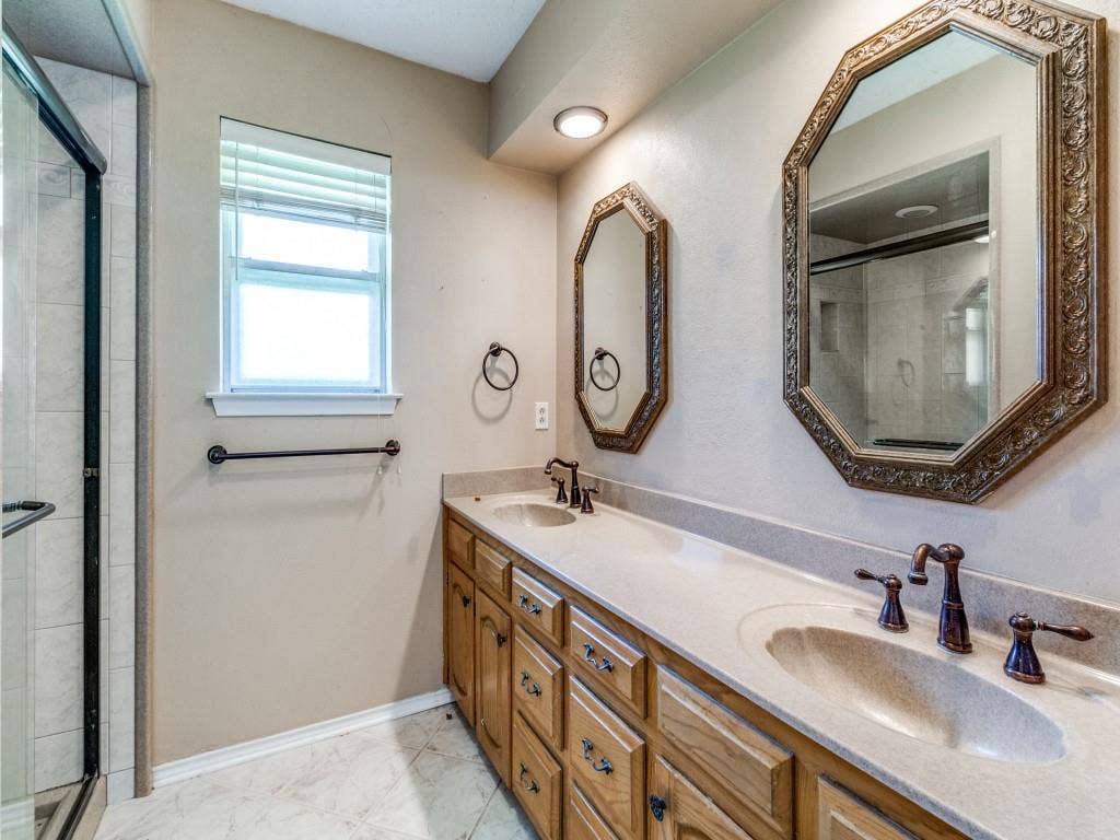 2007 Mistletoe Drive, Richardson, TX 75081 Primary bathroom featuring a shower stall, double vanity, and marble finish floors