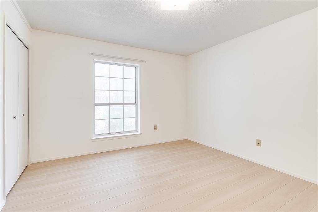 2007 Mistletoe Drive, Richardson, TX 75081 Unfurnished bedroom with multiple windows, light wood-style flooring, a closet, and baseboards