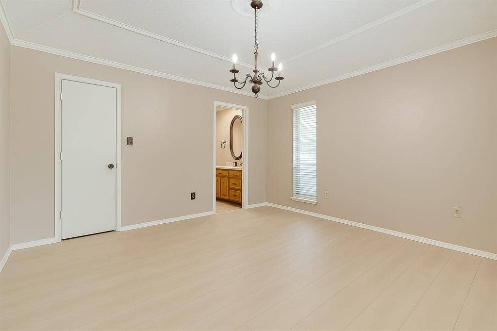 2007 Mistletoe Drive, Richardson, TX 75081 Primary bedroom featuring a chandelier, crown molding, and baseboards