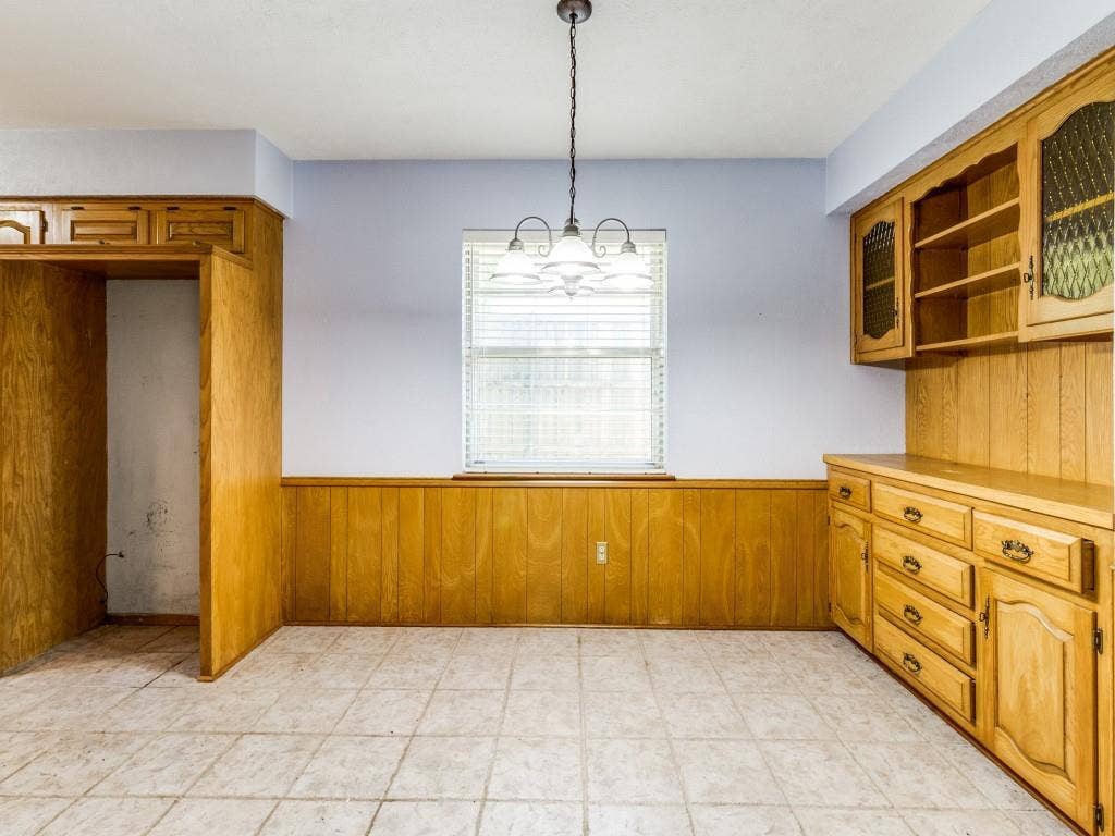 2007 Mistletoe Drive, Richardson, TX 75081 Unfurnished dining area with a wainscoted wall, wood walls, and a chandelier