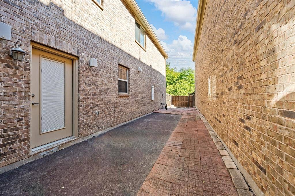 1712 Coronado Street, Allen, TX 75013 Multi-story brick exterior with a paved walkway, external lighting fixtures, and a recessed door