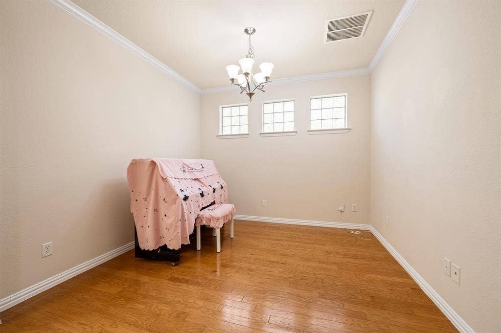 1712 Coronado Street, Allen, TX 75013 Interior space featuring wood-finish flooring, crown molding, a multi-light chandelier, and three transom-style windows
