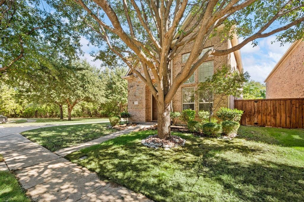 1712 Coronado Street, Allen, TX 75013 Brick exterior featuring multi-story window configurations, concrete paved walkways, manicured landscaping, and mature trees