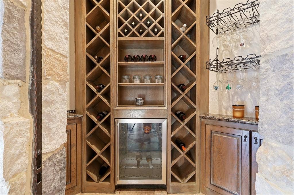1919 Kings Pass, Heath, TX 75032 Built-in wine storage featuring wood-finish racks, integrated beverage refrigerator, and granite countertops