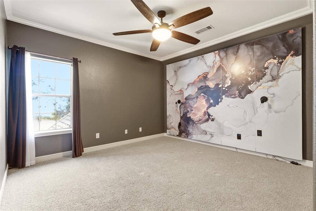 1919 Kings Pass, Heath, TX 75032 Luxe lighting, crown molding, ceiling fan with integrated light, window with white trim, and custom wall feature