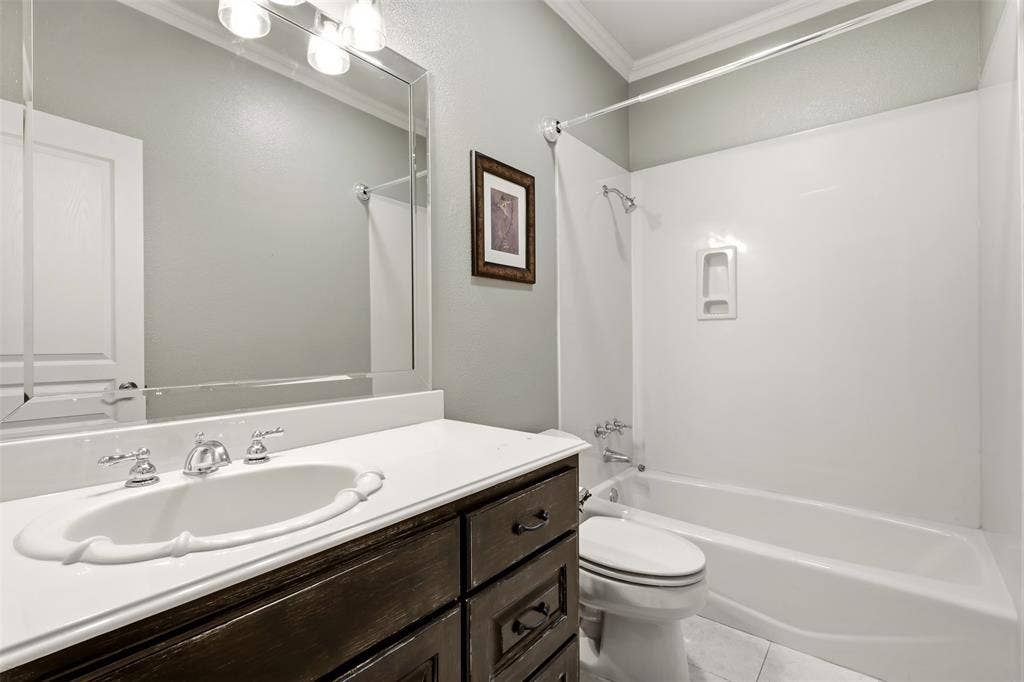 1919 Kings Pass, Heath, TX 75032 White ceramic vanity sink with chrome fixtures, dark wood-finish cabinetry, light countertop, and a white bathtub with shower