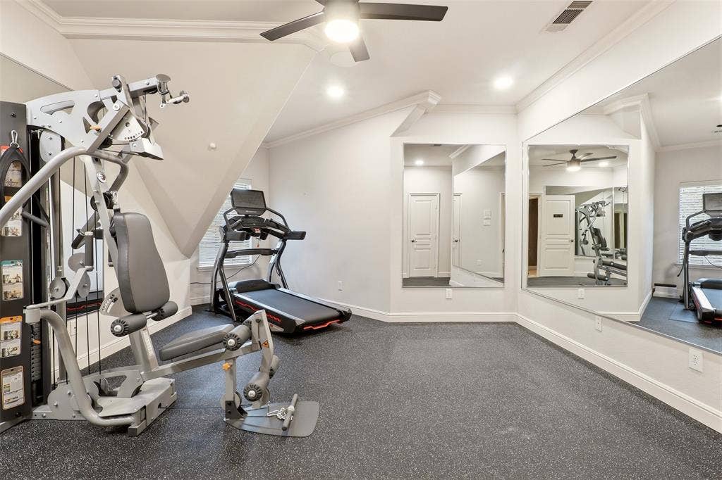 1919 Kings Pass, Heath, TX 75032 Dedicated exercise space featuring durable rubber flooring, wall-mounted mirrors, and an angled ceiling