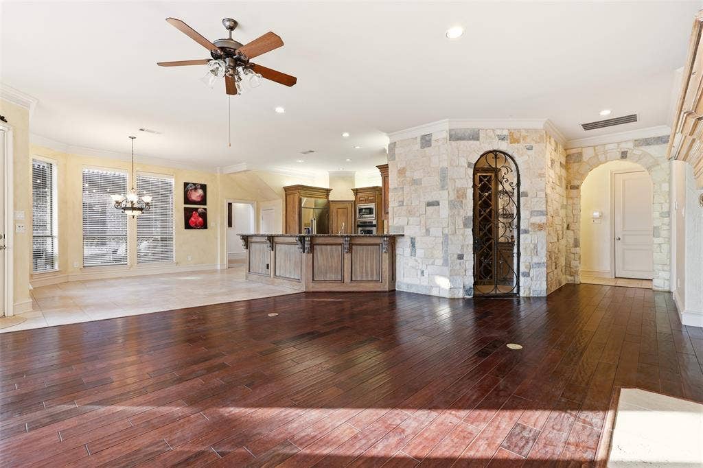 1919 Kings Pass, Heath, TX 75032 Dark wood-finish flooring, stone accent walls, arched doorway, and built-in wine storage