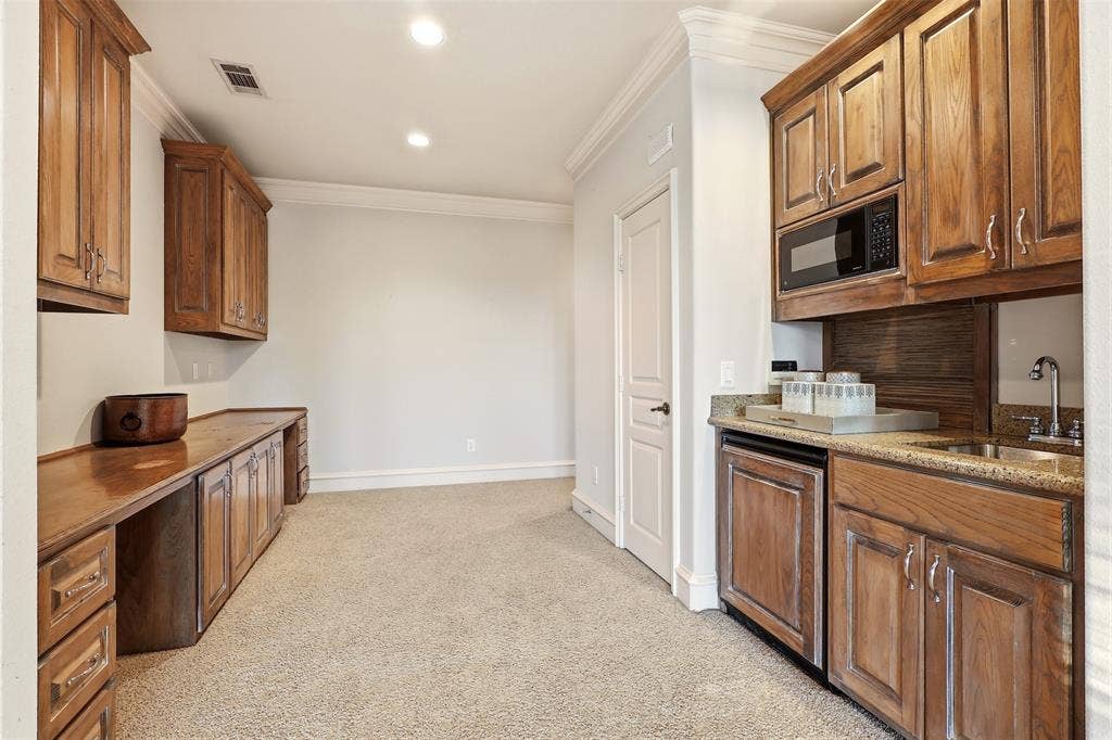 1919 Kings Pass, Heath, TX 75032 Built-in cabinetry with wood-finish, recessed lighting, crown molding, integrated microwave, and a wet bar with a sink