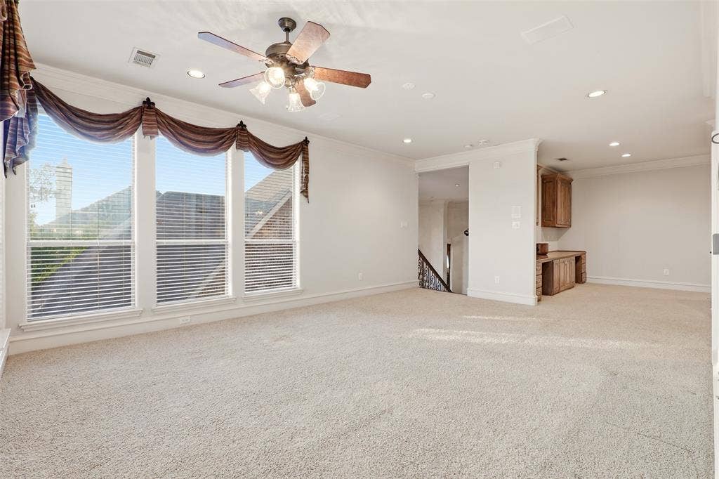 1919 Kings Pass, Heath, TX 75032 Expansive carpeted area featuring a ceiling fan with integrated lighting, recessed lighting, and a built-in desk with cabinetry