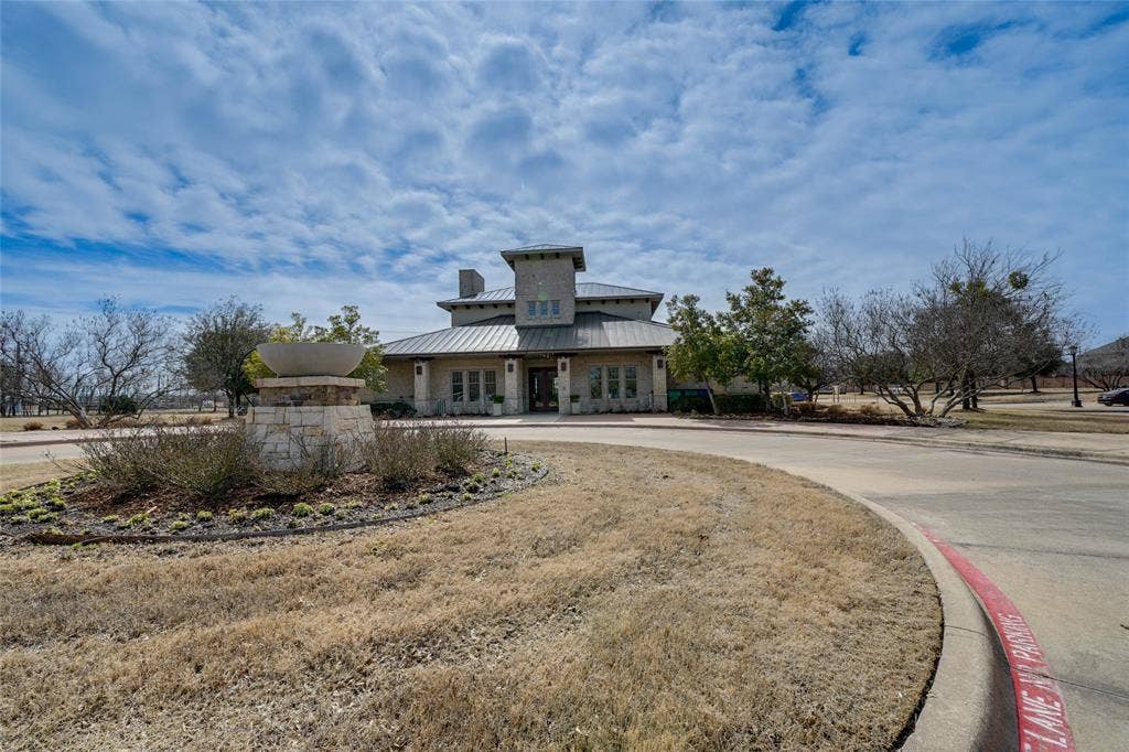 View of front of house with a metal roof, french doors, a standing seam roof, and curved driveway