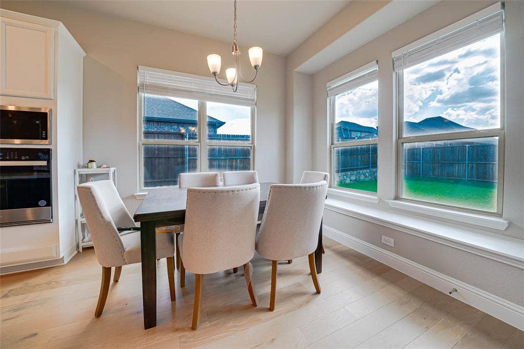 Dining area with light wood-type flooring and a chandelier
