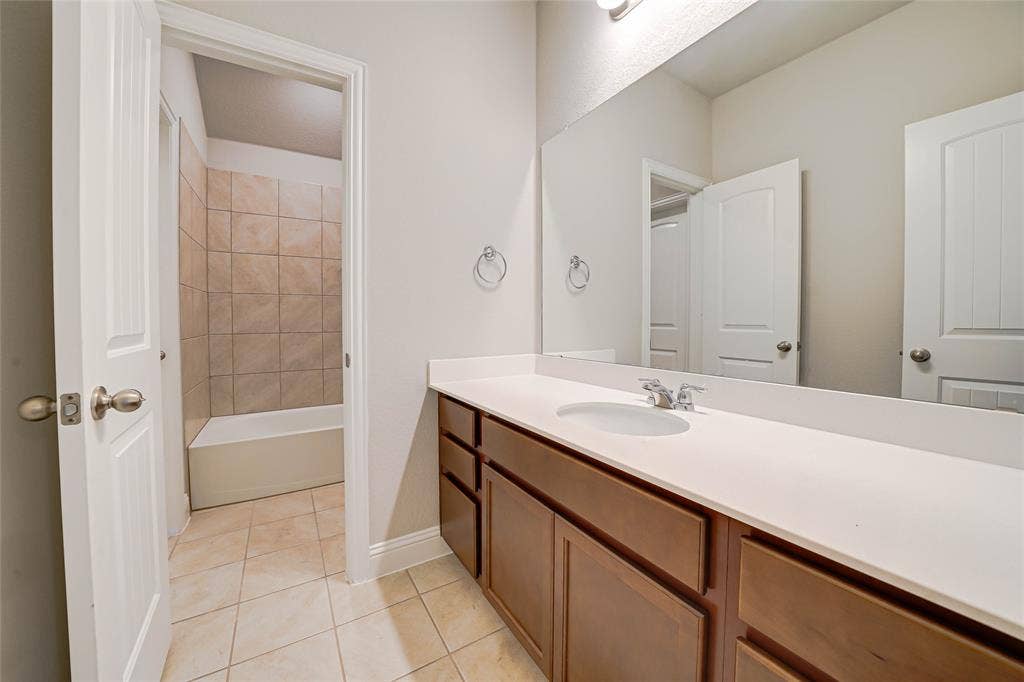 Bathroom featuring vanity, light tile patterned floors, and shower / bathtub combination