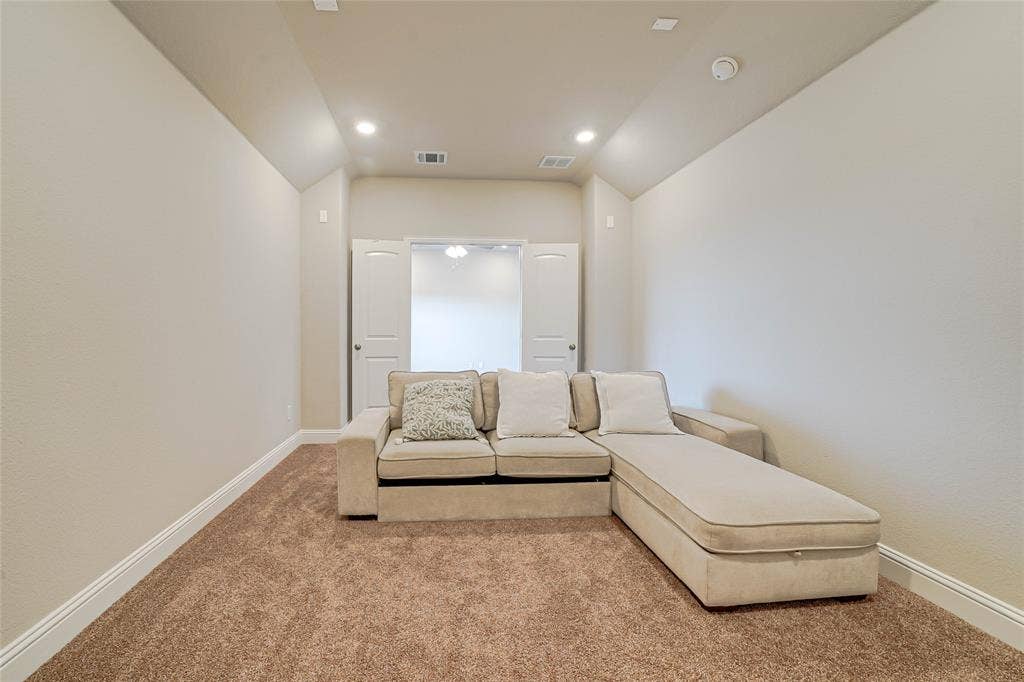 Sitting room with light colored carpet and recessed lighting