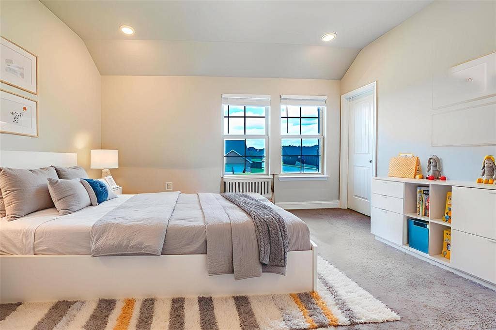 Bedroom featuring light colored carpet, lofted ceiling, recessed lighting, and radiator