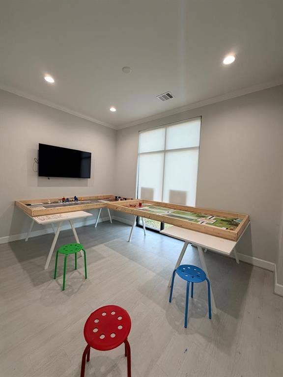 Room featuring neutral-toned walls, wood-finish flooring, recessed lighting, and a large window with a roller shade